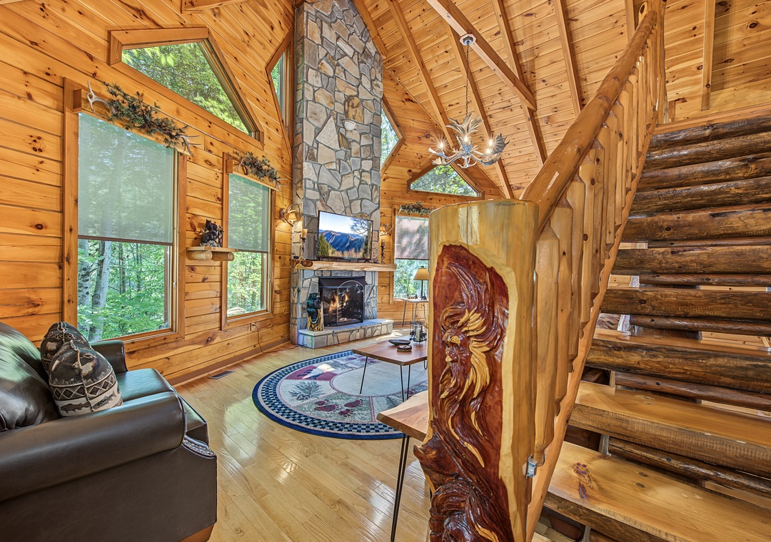 Relax in your inviting living room with soaring cathedral ceilings, a grand stone fireplace, and charming wood-paneled walls that wrap you in warmth and rustic elegance.
