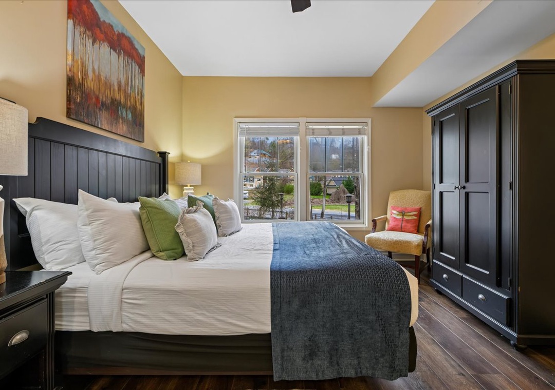 Drift off in this elegantly appointed bedroom where crisp linens meet rich hardwood floors and peaceful neighborhood views.