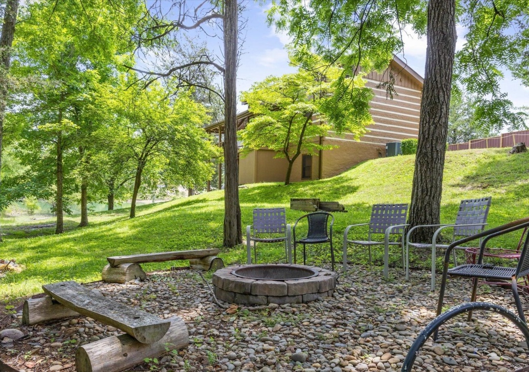 Gather around your private fire pit surrounded by comfortable seating, where you'll create lasting memories under towering trees in this peaceful wooded setting.