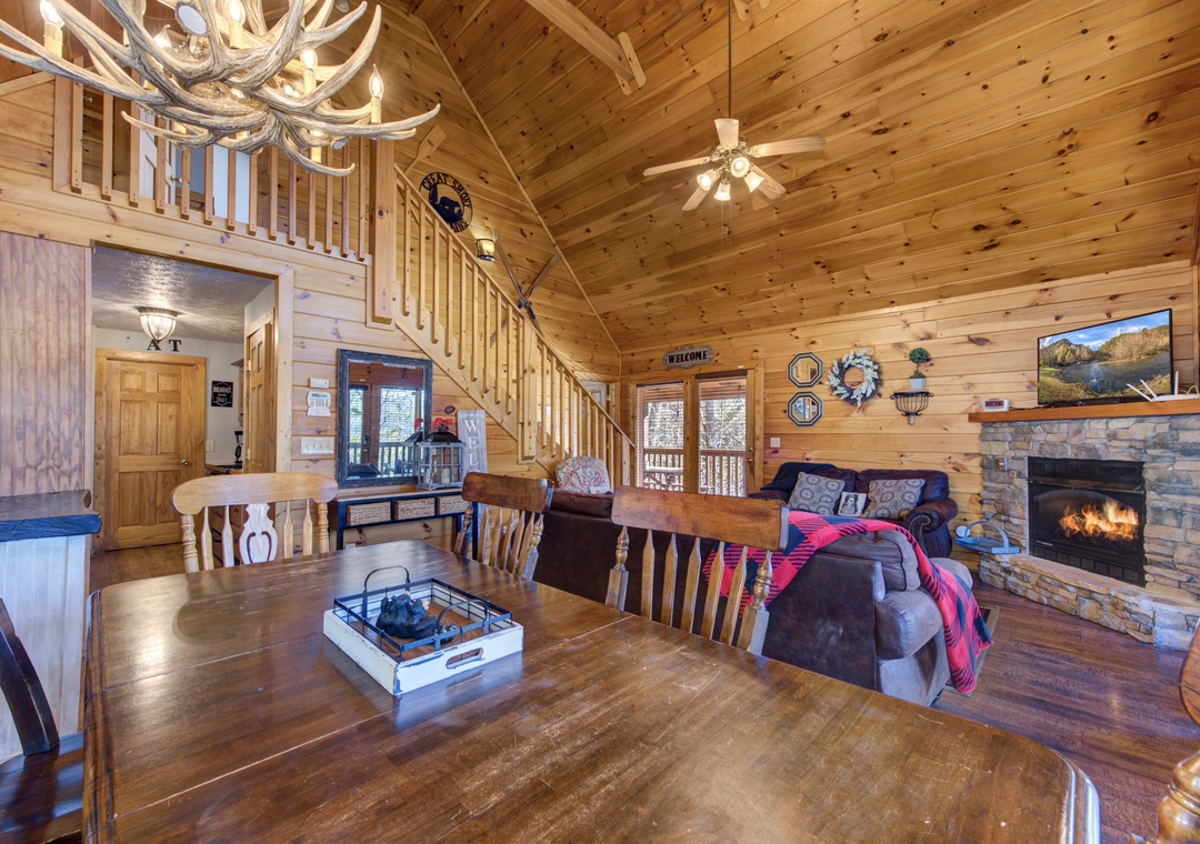 Cozy up in this rustic cabin with rich wood details, stone fireplace, and antler chandelier creating your perfect mountain retreat.