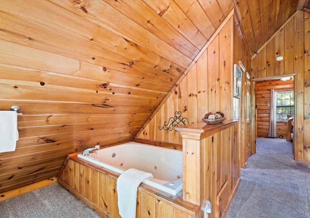 Soak in your private rustic hot tub surrounded by warm wood paneling and cozy cabin charm.