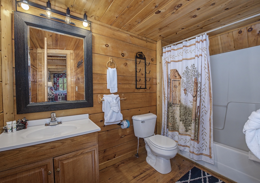 Step into your rustic bathroom where warm wood walls and charming cabin details create a cozy retreat after your mountain adventures.