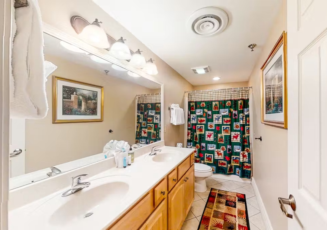 Refresh in your spacious bathroom with dual vanities, festive touches, and abundant lighting for your comfort.