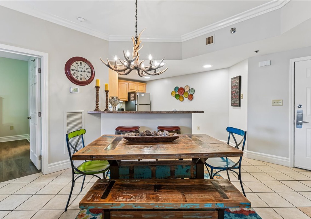 Gather around your rustic dining table beneath the striking antler chandelier, where memorable meals await in this charming space.