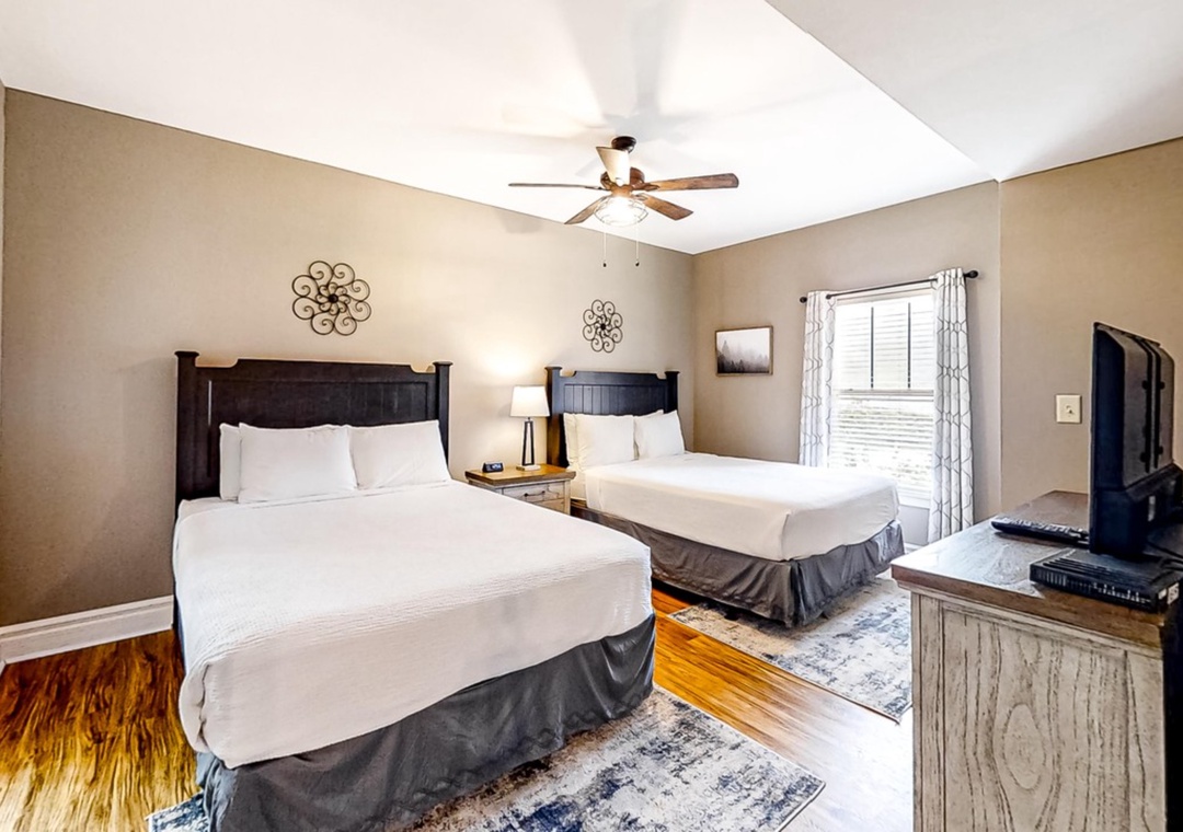 Relax in your spacious bedroom with two comfortable beds, soft lighting, and entertainment - perfect for sharing with family.