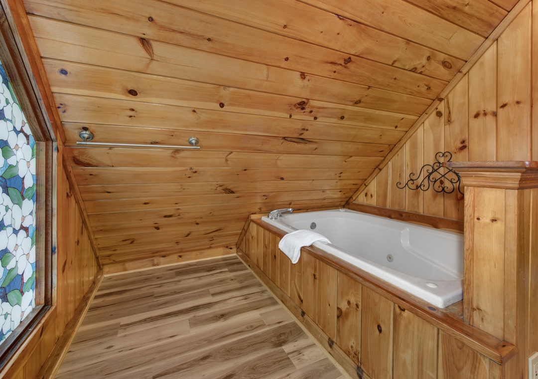 Unwind in your private wooden sanctuary with a soaking tub surrounded by warm cedar walls and colorful stained glass.