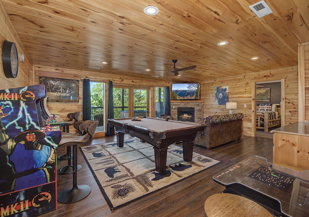 Your entertainment paradise awaits with a pool table, arcade games, and cozy fireplace for perfect mountain cabin evenings together.