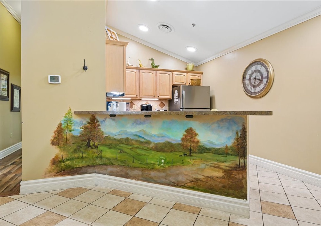 Your fully equipped kitchen features a stunning hand-painted landscape mural, creating an inspiring backdrop for your culinary adventures.