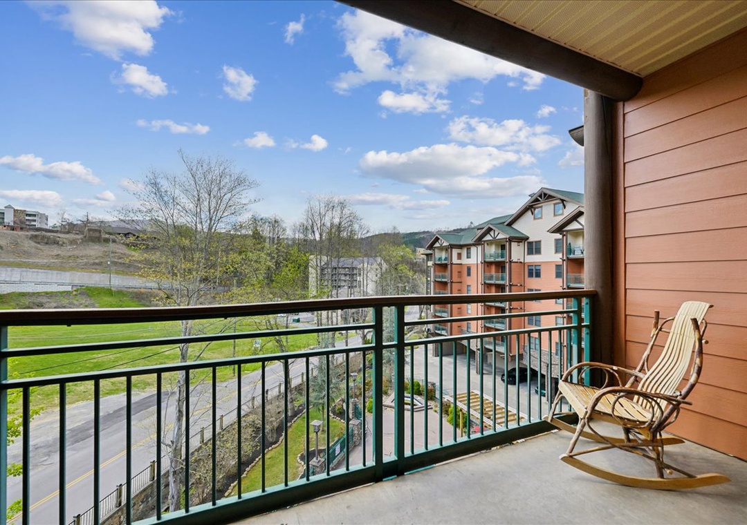 Your private balcony offers peaceful views of rolling hills and nearby buildings, perfect for morning coffee in the rocking chair.