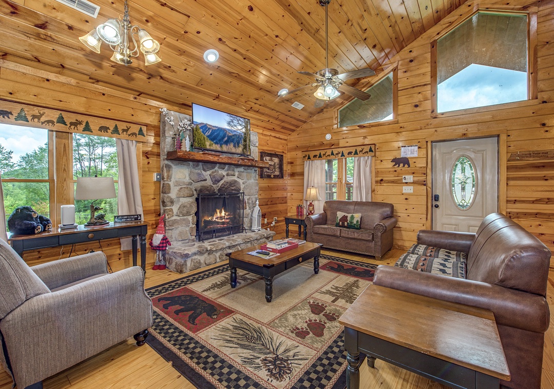 Cozy up by the stone fireplace in your rustic living room, where soaring ceilings, warm wood walls, and mountain-inspired décor create a welcoming retreat after your adventures.