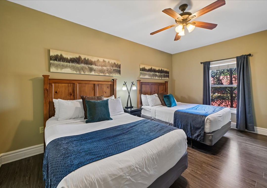 Rest comfortably in your twin bed bedroom featuring warm wood headboards, nature-inspired artwork, and a ceiling fan for perfect temperature control.