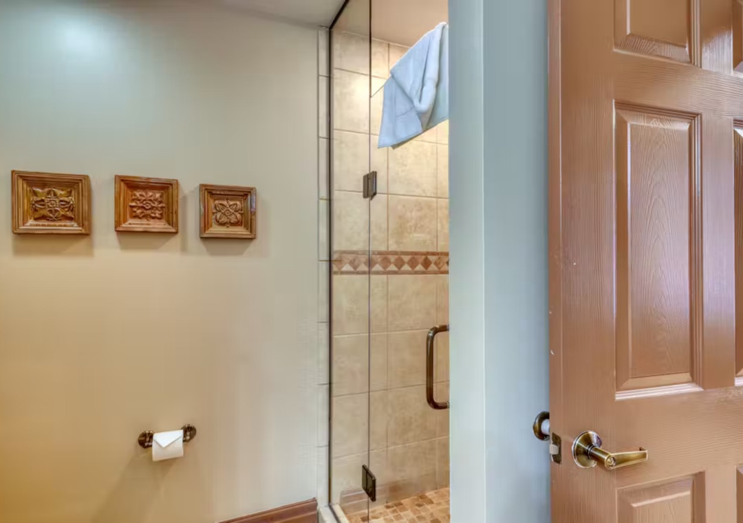 Step into your private spa-like shower with beautiful tile work and warm decorative touches that make every morning feel luxurious.