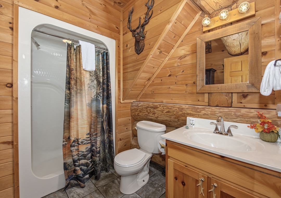 Step into your own rustic retreat—a cozy bathroom featuring warm wood walls, charming cabin décor, and everything you need to freshen up in comfort after a day of adventure.