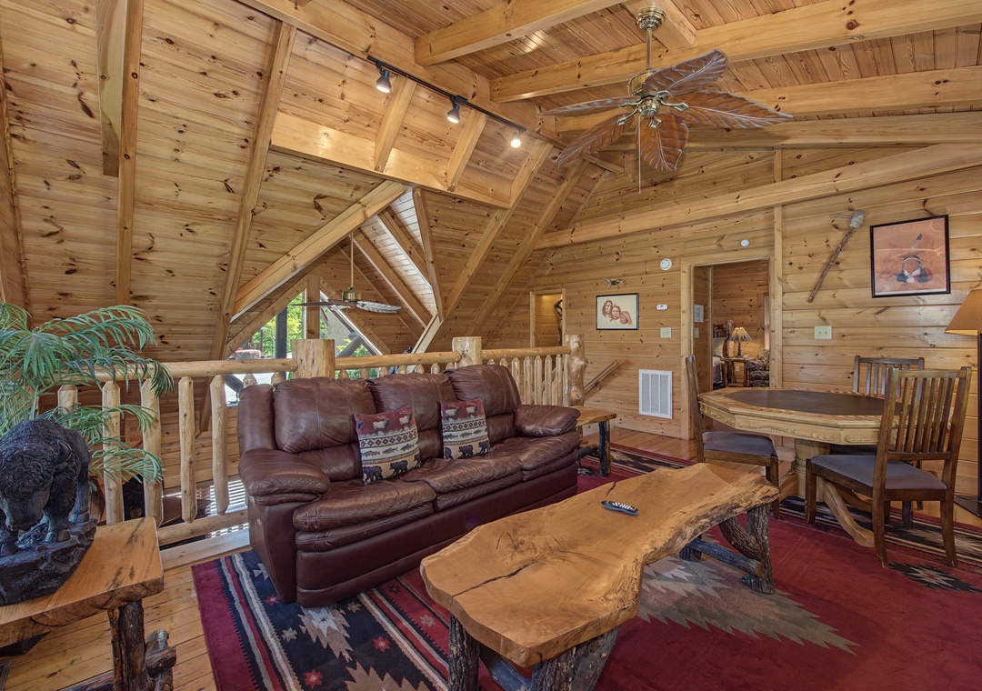 Your rustic log cabin living room welcomes you with soaring beam ceilings, rich leather seating, and warm wood everywhere you look.