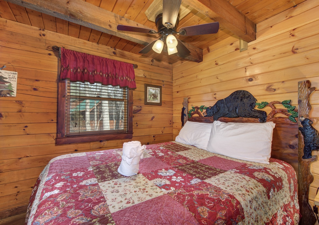 Relax in your cozy log cabin bedroom with rustic charm, unique carved headboard, and warm wood walls creating the perfect mountain retreat.