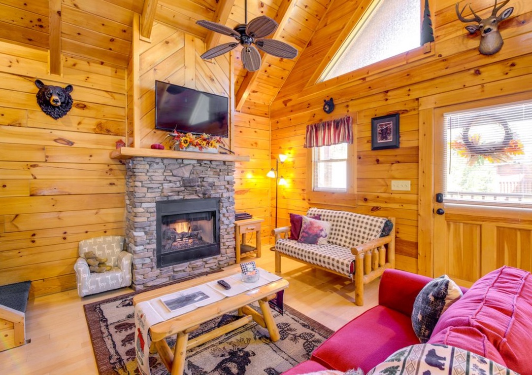 Unwind in your cozy cabin living room with a crackling fireplace and rustic charm surrounding you.