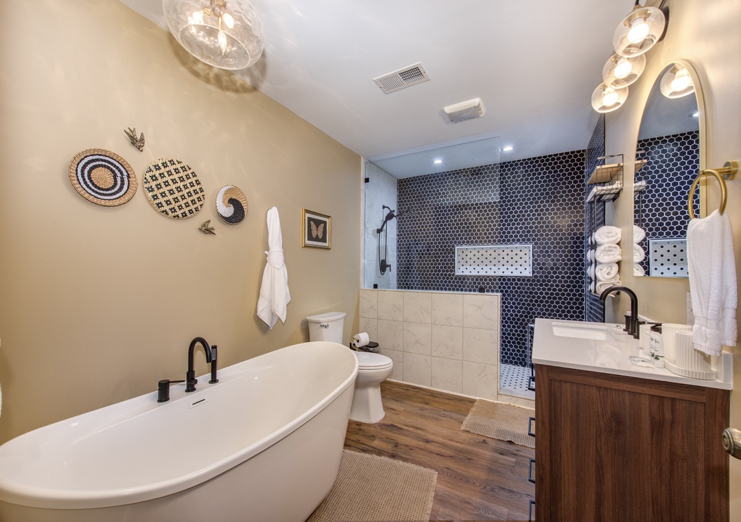 Unwind in your spa-like bathroom featuring a soaking tub, elegant vanity, and beautiful tiled shower perfect for luxurious relaxation.