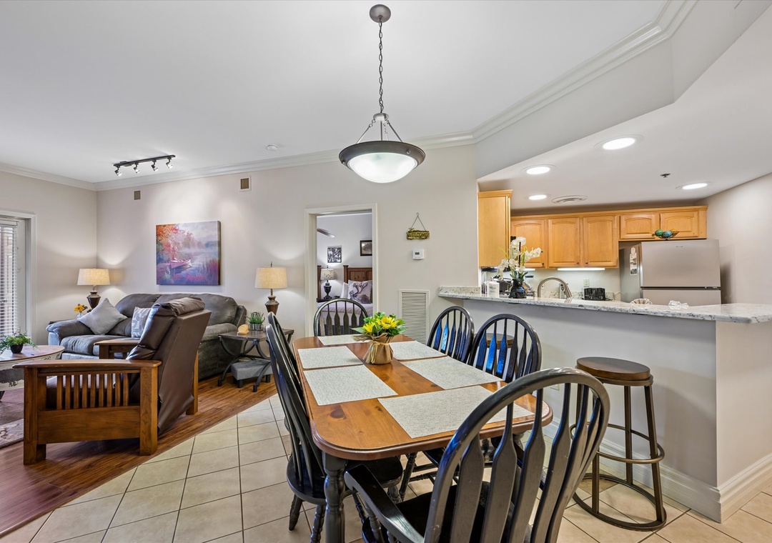 Picture yourself gathered around this inviting dining table, sharing meals and stories with your loved ones, while the fully equipped kitchen stands ready for your culinary adventures.