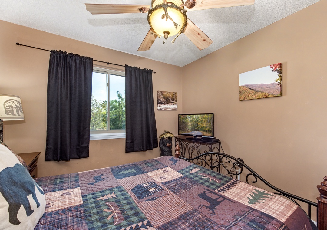 Your cozy bedroom features rustic decor with a quilt-covered bed, warm lighting, and mountain artwork to help you unwind after adventures.