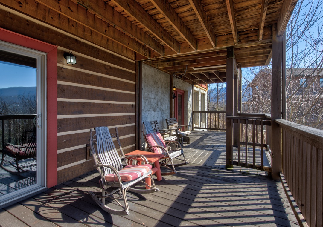 Your private covered deck beckons with rocking chairs and mountain views, perfect for morning coffee or evening relaxation.