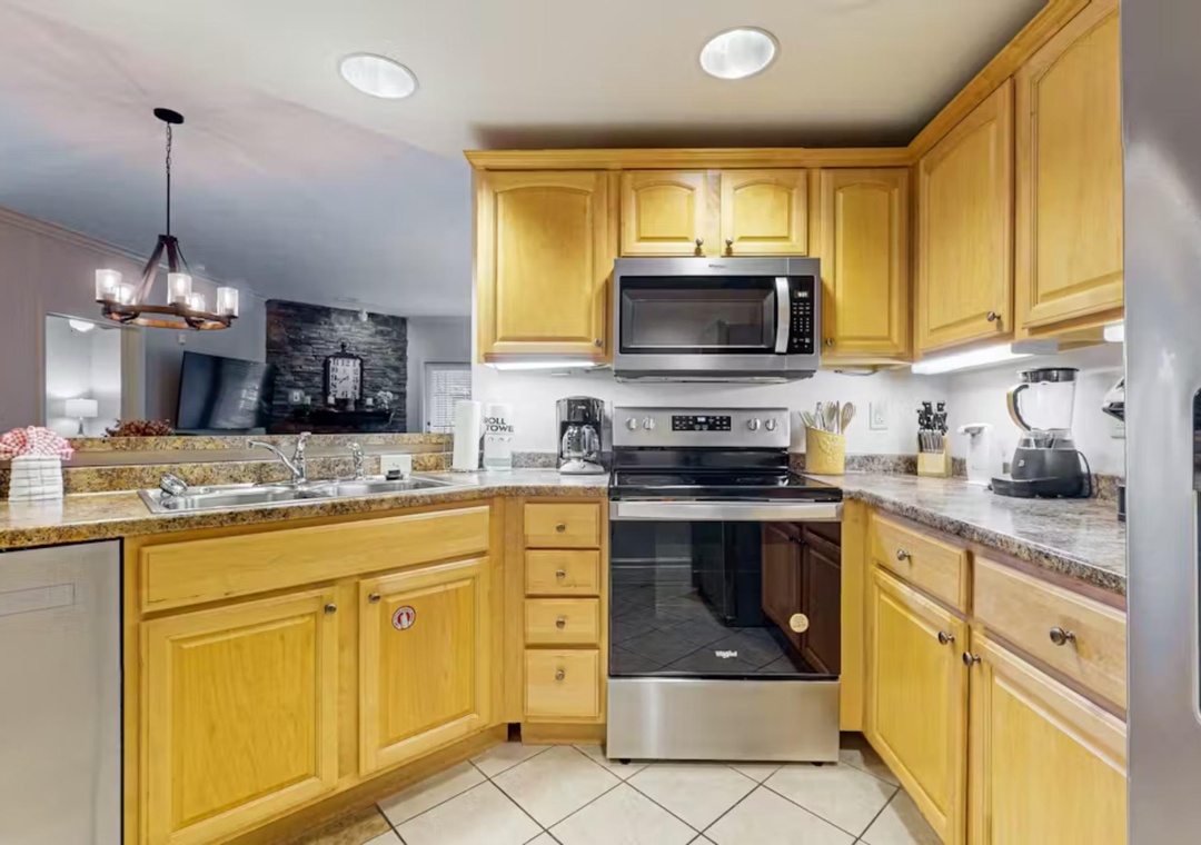 Whip up your favorite meals in this fully-equipped kitchen featuring granite countertops, stainless steel appliances, and warm wood cabinetry with plenty of storage space.