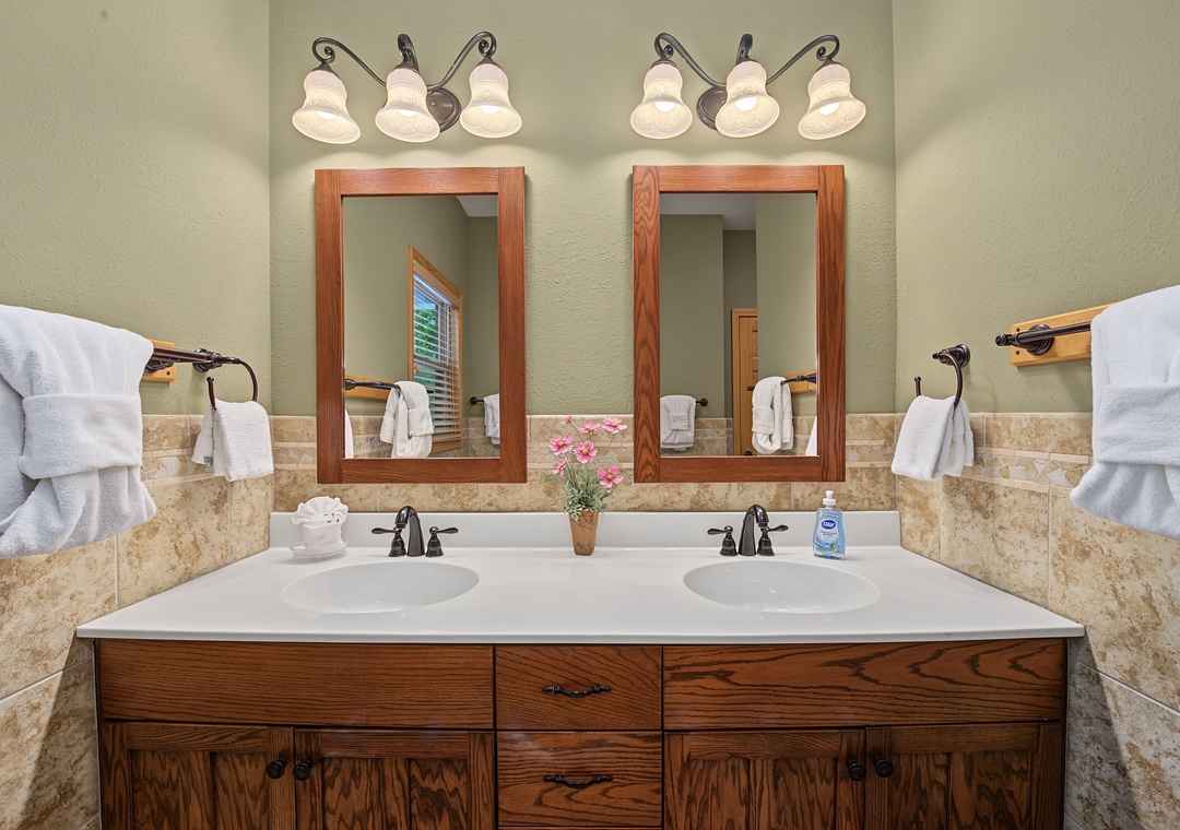 Freshen up at your spacious double vanity with wood-framed mirrors, elegant lighting, and plush towels waiting just for you.