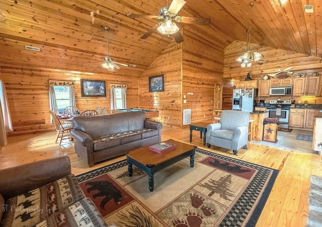 Step into your rustic retreat where vaulted ceilings and warm wood create a welcoming escape. Unwind in the open living space while sunlight streams through windows framing peaceful views.