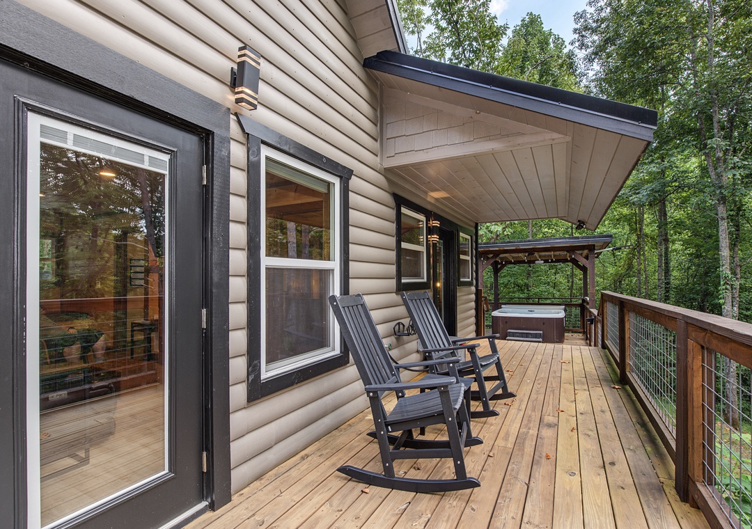 Step onto your private deck where two rocking chairs invite you to unwind surrounded by lush forest. The covered area and hot tub provide the perfect setting for peaceful mornings or starlit evenings.