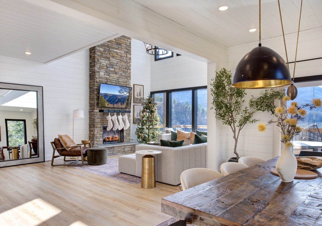 Unwind in this stunning open-concept space where modern design meets cozy comfort, featuring a crackling fireplace and breathtaking mountain views.