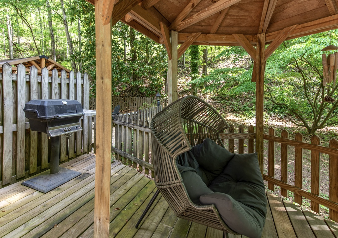 Your private deck invites peaceful mornings with forest views, a cozy swing, and a grill ready for outdoor meals surrounded by nature.