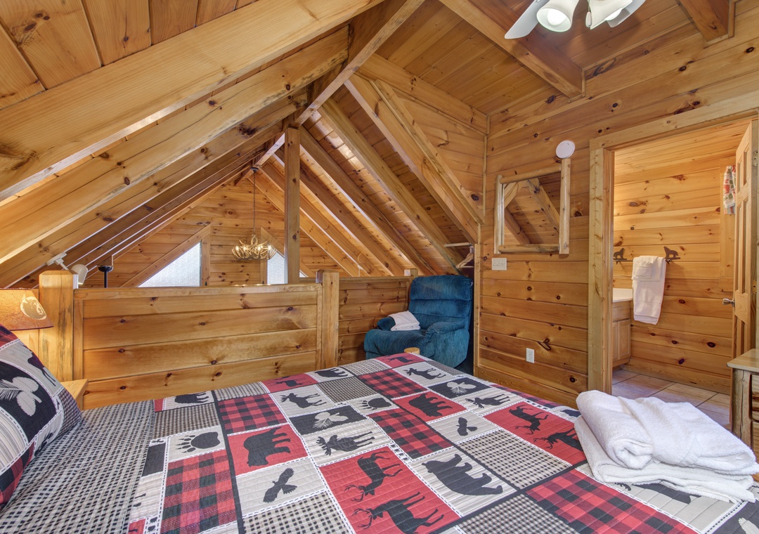 Cozy up in your rustic loft bedroom, where exposed wooden beams create intimate alpine charm and plaid linens invite peaceful mountain dreams.