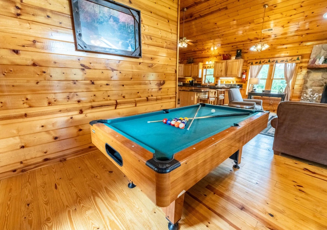 Challenge friends to a game of pool in your cozy cabin retreat, where rustic wood walls and open-plan living create the perfect atmosphere for relaxed mountain evenings together.