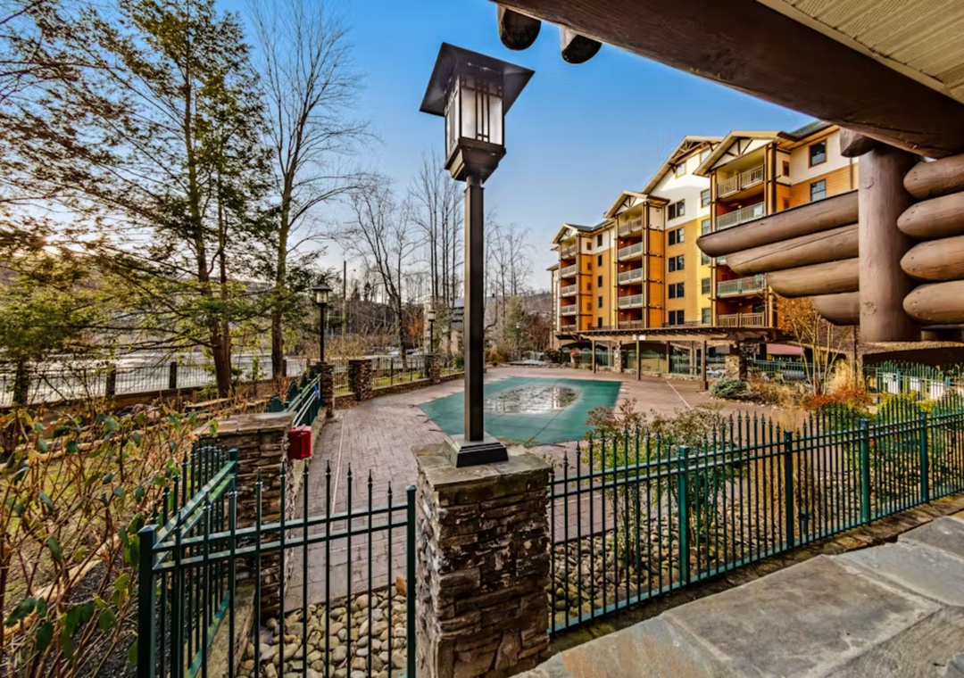 Resort-style pool area surrounded by multi-story buildings and natural landscaping creates a welcoming mountain getaway atmosphere.