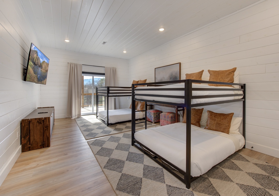 Your kids will love this bright bunk room featuring cozy beds, entertainment, and sliding door access to outdoor adventures.