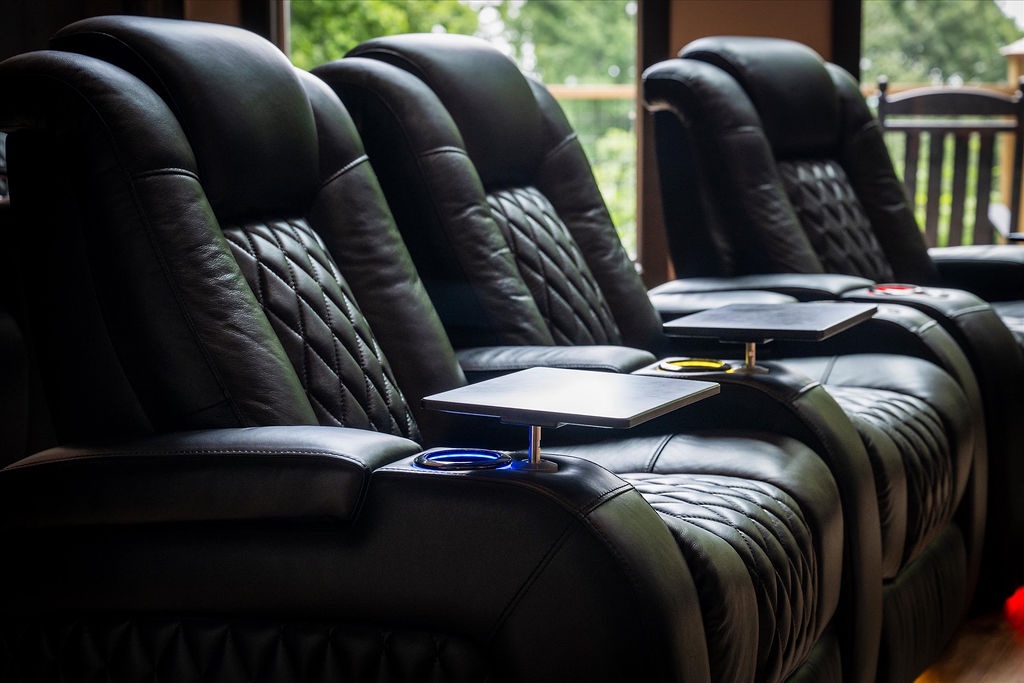 Sink into plush leather recliners with built-in tray tables—your front-row seat for movie marathons, game nights, or simply unwinding with a view of the leafy outdoors.