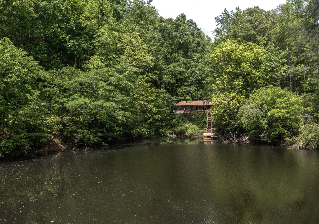 A secluded waterfront cabin nestled among lush forest along a peaceful river, offering serene natural surroundings and private water access for a tranquil escape.