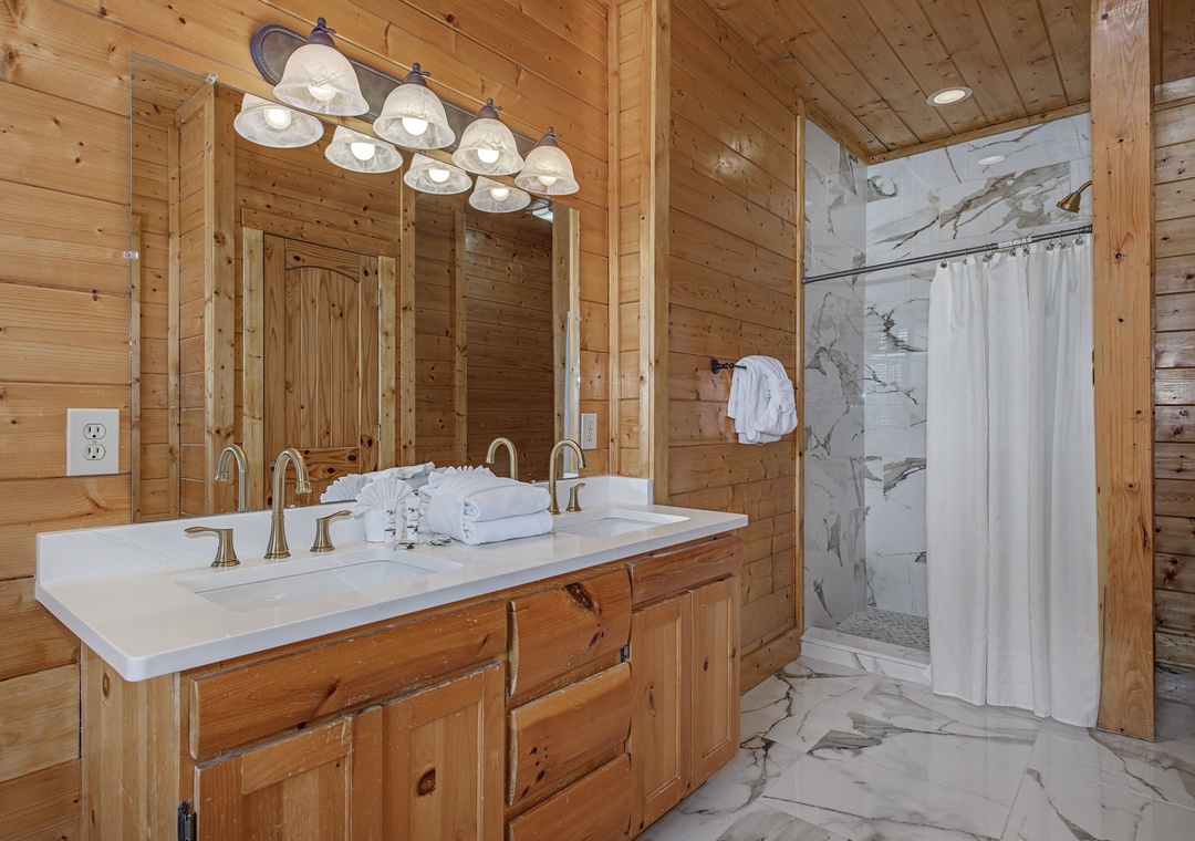Unwind in your luxurious cabin bathroom where rustic wood meets elegant marble, creating the perfect spa-like retreat after your mountain adventures.
