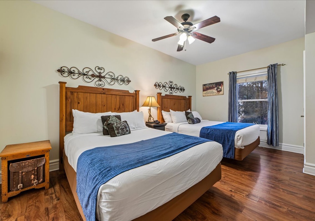 Relax in your spacious twin bedroom with rustic wood furnishings, crisp linens, and gentle ceiling fan keeping you comfortable throughout your stay.