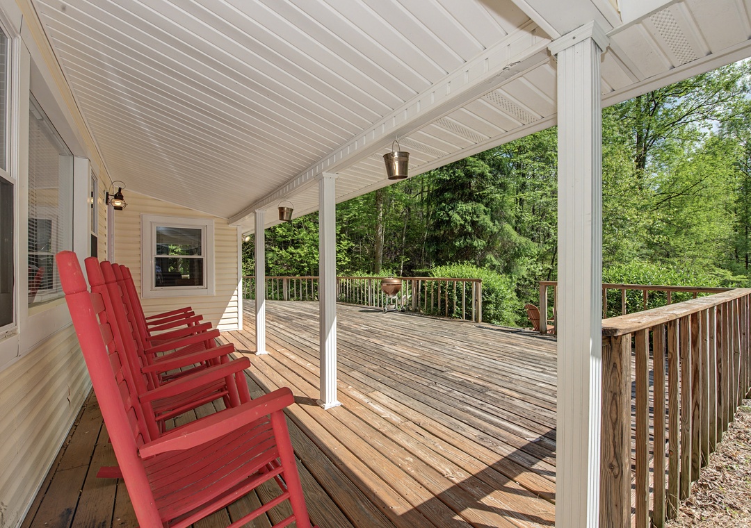 Your private covered deck awaits with comfy red chairs for morning coffee and peaceful forest views.