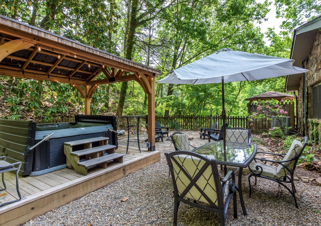 Your private backyard oasis features a relaxing hot tub, shaded dining area, and serene forest views—perfect for unwinding after a day of adventure.