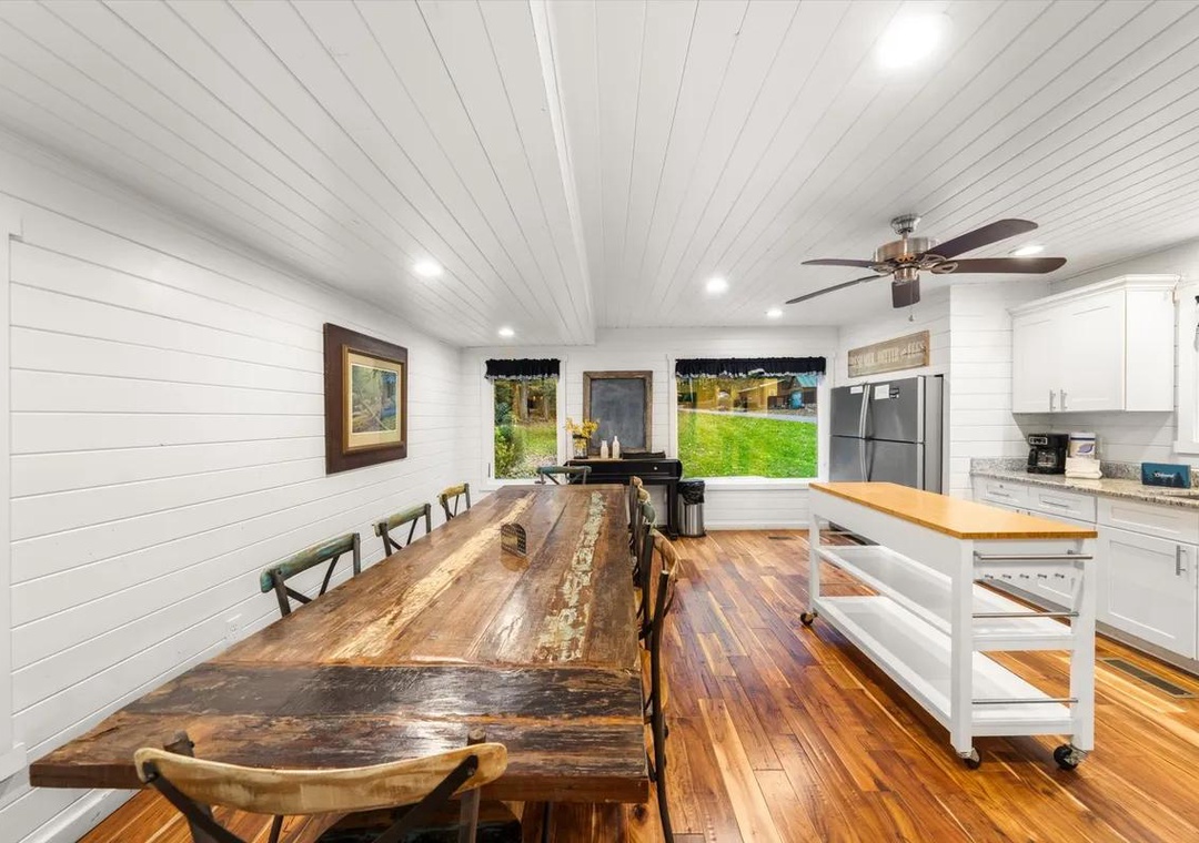 Gather around this stunning live-edge dining table where your mornings feel bright and inviting. Natural wood textures and crisp white shiplap create a warm farmhouse vibe, while the fully-equipped kitchen makes meal prep a joy.