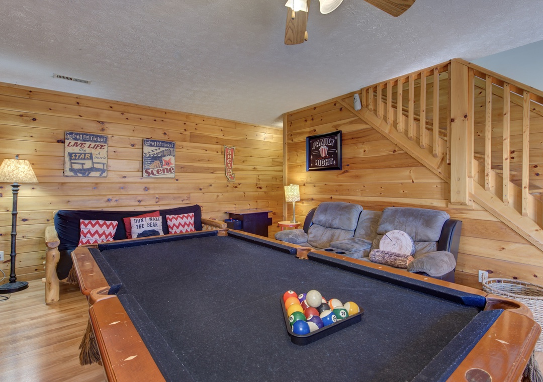Challenge friends to pool in your cozy game room featuring warm wood walls and comfortable seating for tournament breaks.