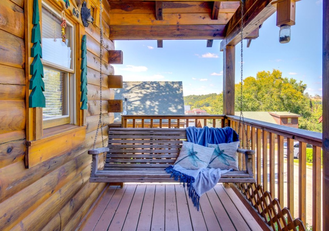 Swing gently on your private porch swing, wrapped in cozy blankets while taking in peaceful treetop views from this charming log cabin retreat.