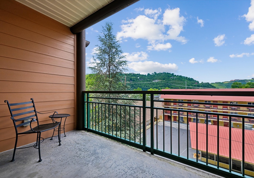 Step onto your private balcony and take in the rolling green hills framing the horizon. A cozy chair invites quiet morning coffee or evening reflection.