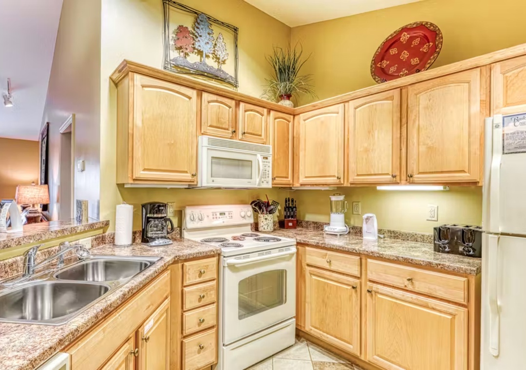 Your fully equipped kitchen awaits with granite counters, warm wood cabinets, and everything needed for home-cooked meals during your stay.