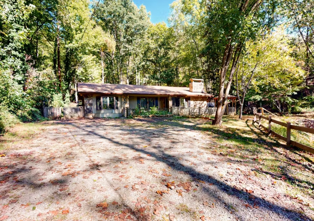 Charming woodland retreat nestled among towering trees with rustic cabin architecture and peaceful natural surroundings.