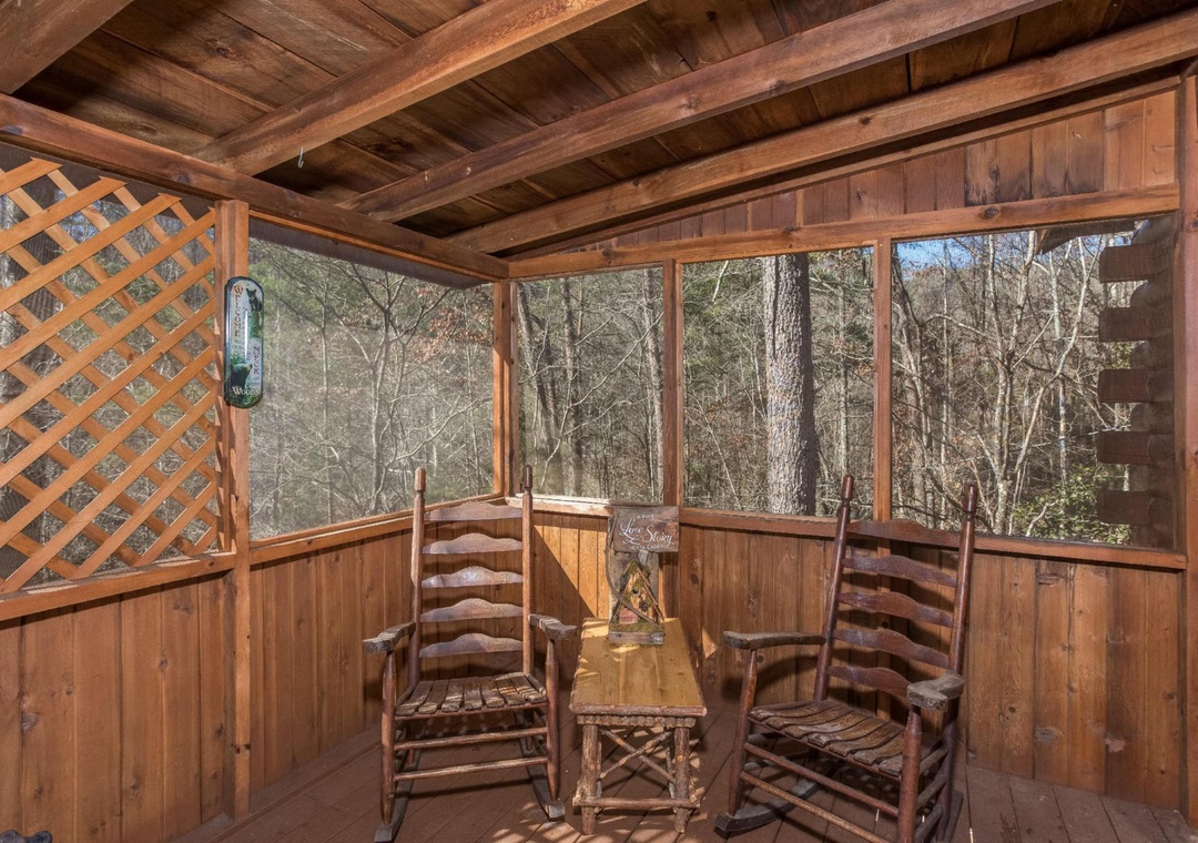 Step onto your screened porch and settle into rustic rocking chairs that overlook a peaceful wooded setting—perfect for morning coffee or evening conversations surrounded by nature.