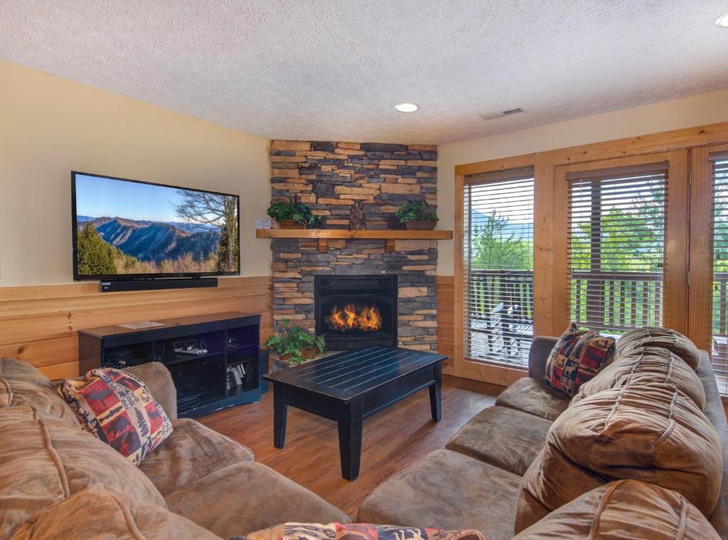 Cozy up by the stone fireplace while watching your favorite shows on the flat-screen TV, surrounded by plush seating and mountain views.