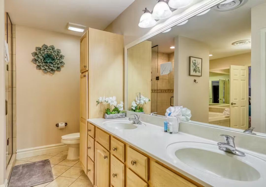 Freshen up in your spacious master bathroom with dual sinks, elegant granite counters, and thoughtful touches like fresh orchids welcoming you home.