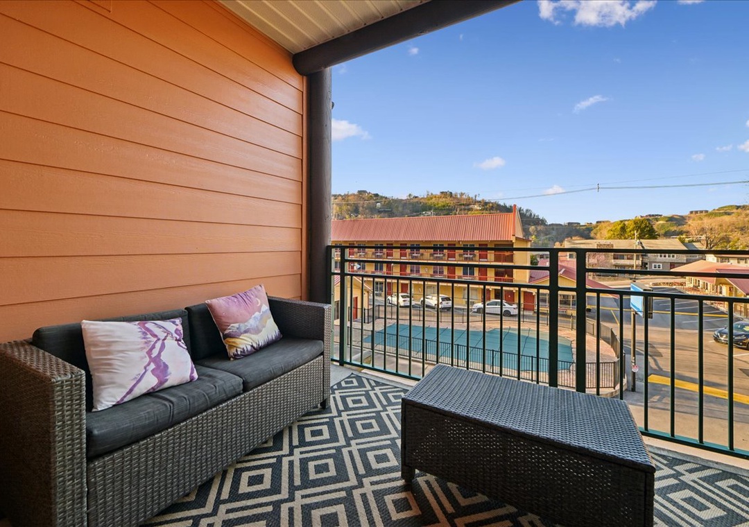Unwind on your private balcony with comfortable seating overlooking the vibrant neighborhood below.